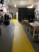 Yellow paint road, Hackitorium to back -- Accessibility and fire Safety, past Flaschen Taschen, Lockers, CNC/Fabrication, and the Wood Shop, from Reboot24